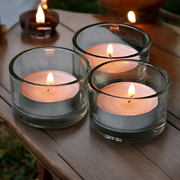 Round glass holders with lit tealights in a small table display
