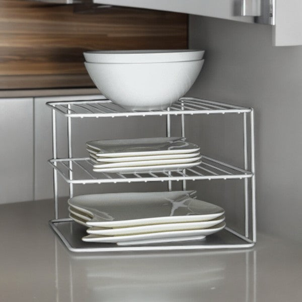 White two-tier cupboard shelf holding plates and bowls