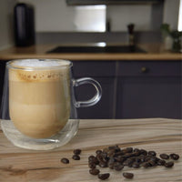 275ml double-walled glass mug holding coffee on a wooden counter