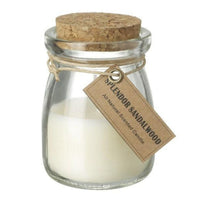 Clear glass sandalwood candle with cream wax, cork lid and hanging label
