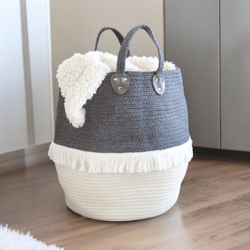 Large grey and cream cotton rope basket holding a folded throw