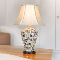 Illuminated ivory butterfly table lamp on a wooden table
