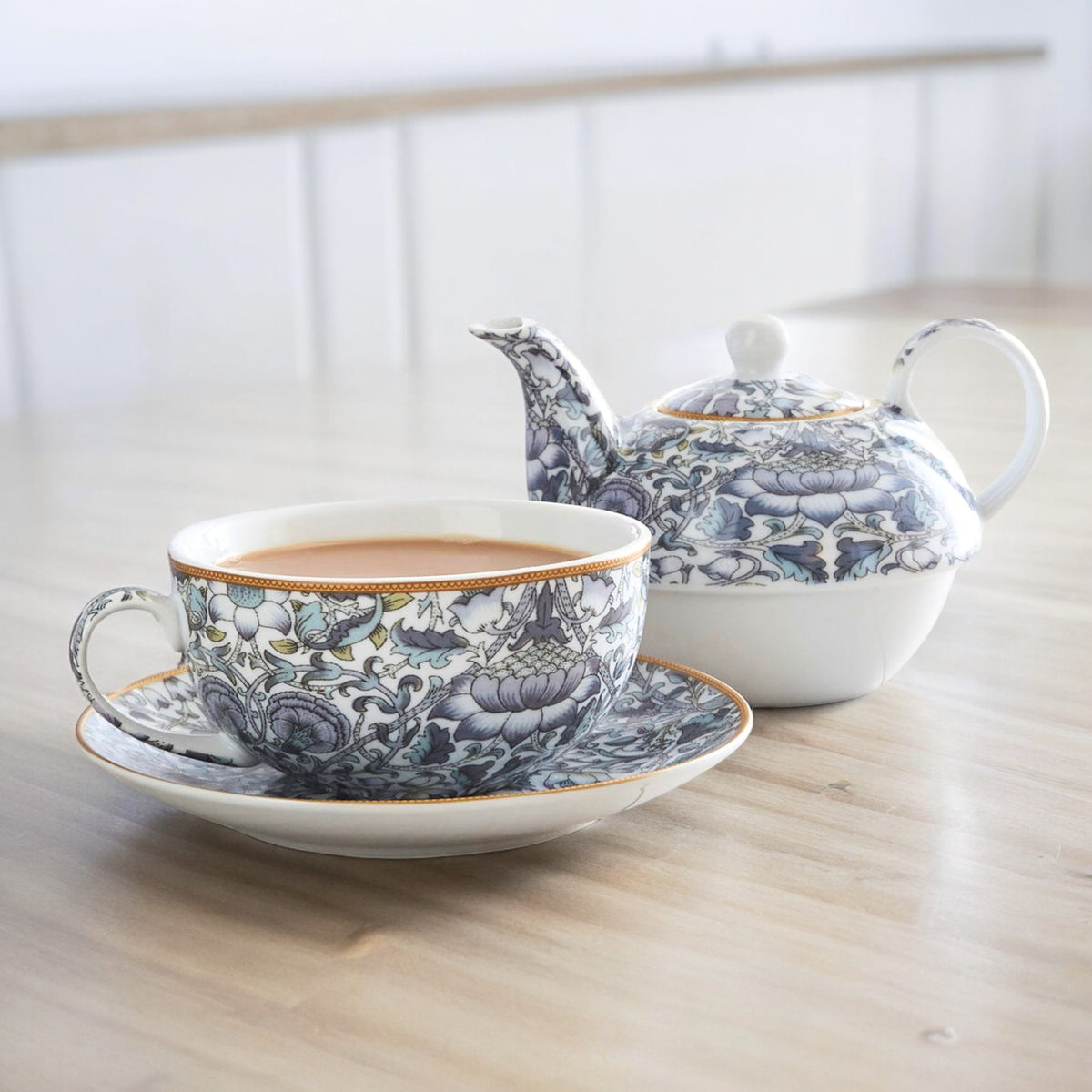 Lodden floral teacup and saucer beside the matching teapot