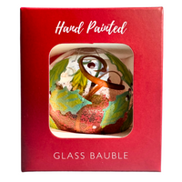 Yellow-design glass bauble with leaves in a red window box