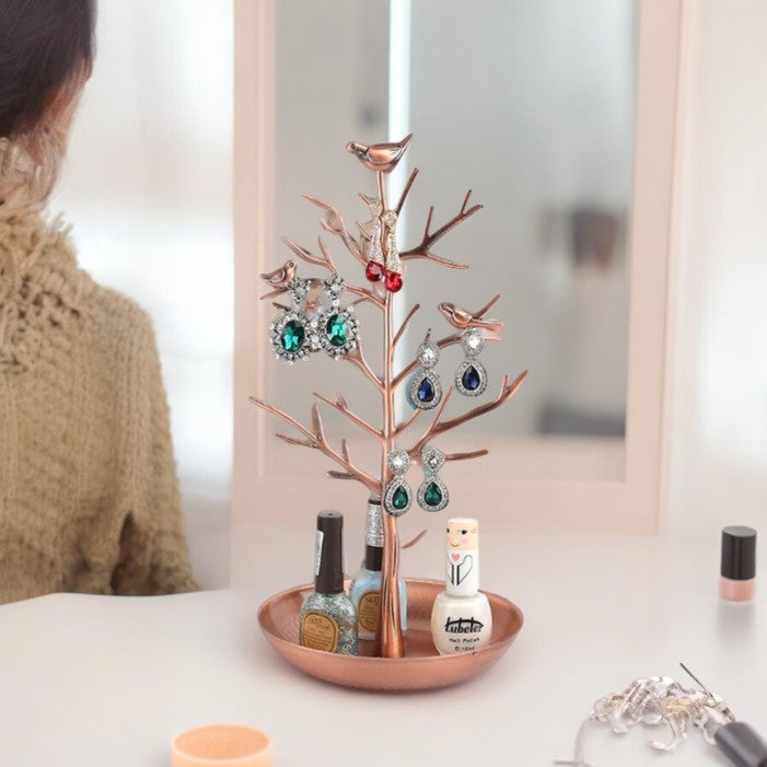 Rose-gold bird jewellery tree displaying earrings above a round tray