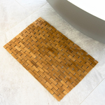 Non-slip bamboo bath mat for safe bathroom navigation.