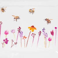 Close-up of bees and pink, purple and yellow flowers on the serving tray
