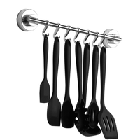 Silver-coloured suction wall rail holding kitchen utensils on seven hooks