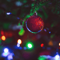 Coloured lights beside a red Christmas bauble