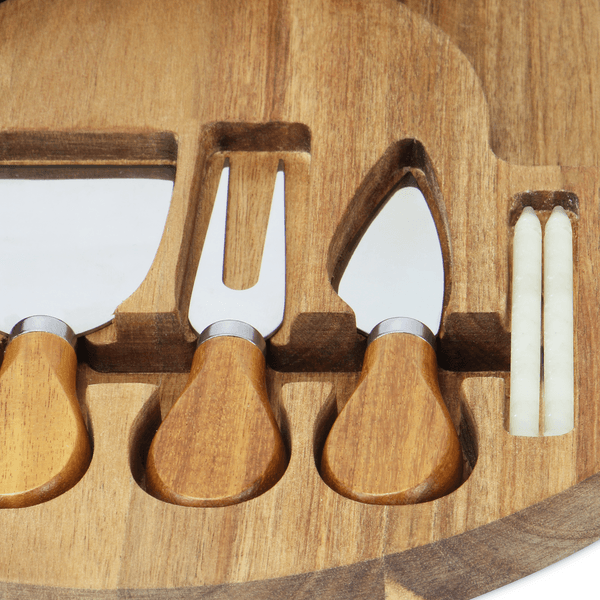 Close-up of cheese shaver, knife and fork in fitted wooden slots