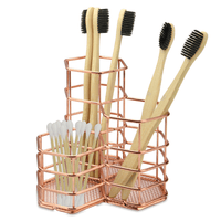Hexagonal rose gold tidy holding toothbrushes and cotton buds