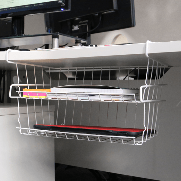 Two white storage baskets hanging beneath an office desk