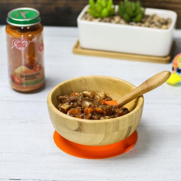 Bamboo suction bowl filled with food and the spoon inside