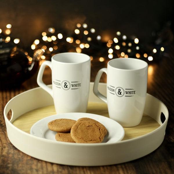 Round tray holding two mugs and a plate of biscuits