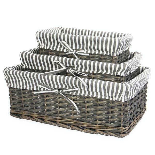 Three grey wicker baskets in graduated sizes with striped liners