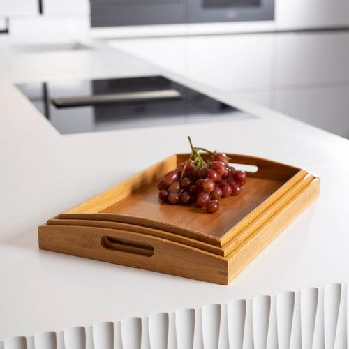 Stacked set of three bamboo serving trays, nested for compact storage.