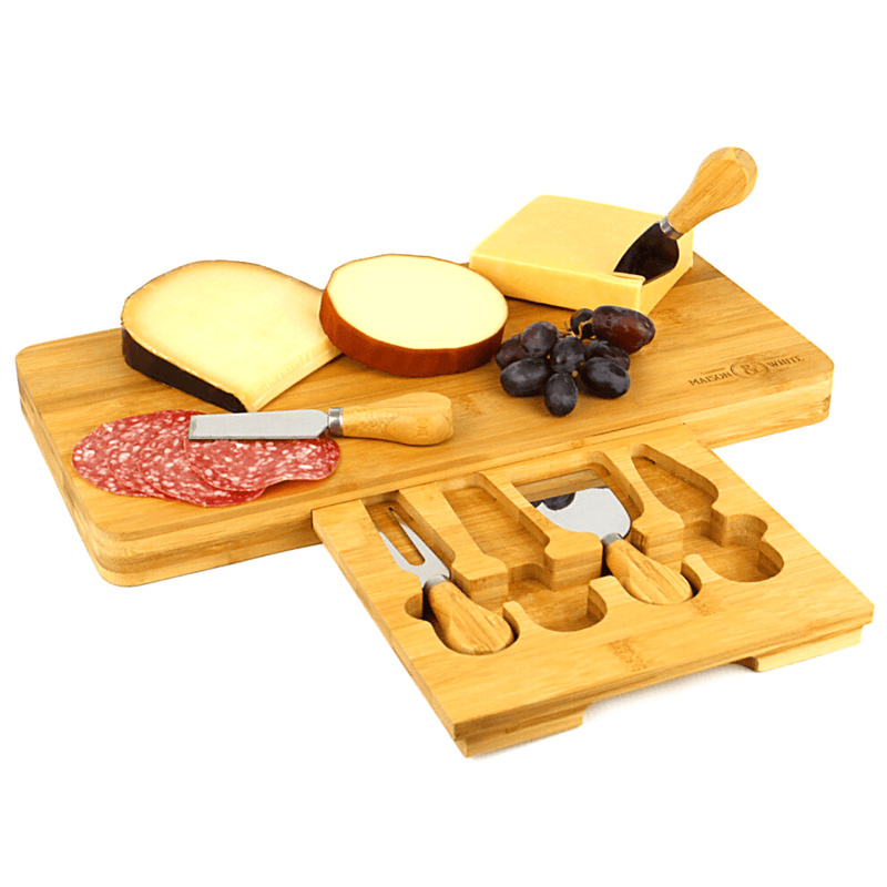Bamboo cheese board with cheese and an open utensil drawer