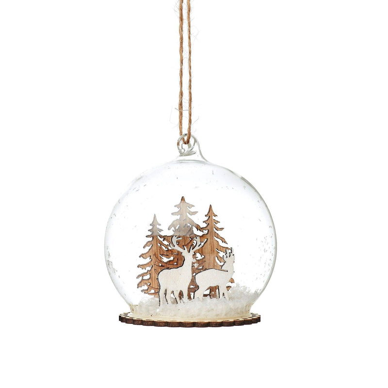 Clear glass dome bauble enclosing wooden stags and trees in a snowy woodland scene
