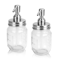 Two clear glass mason jar soap dispensers with silver-coloured pump tops
