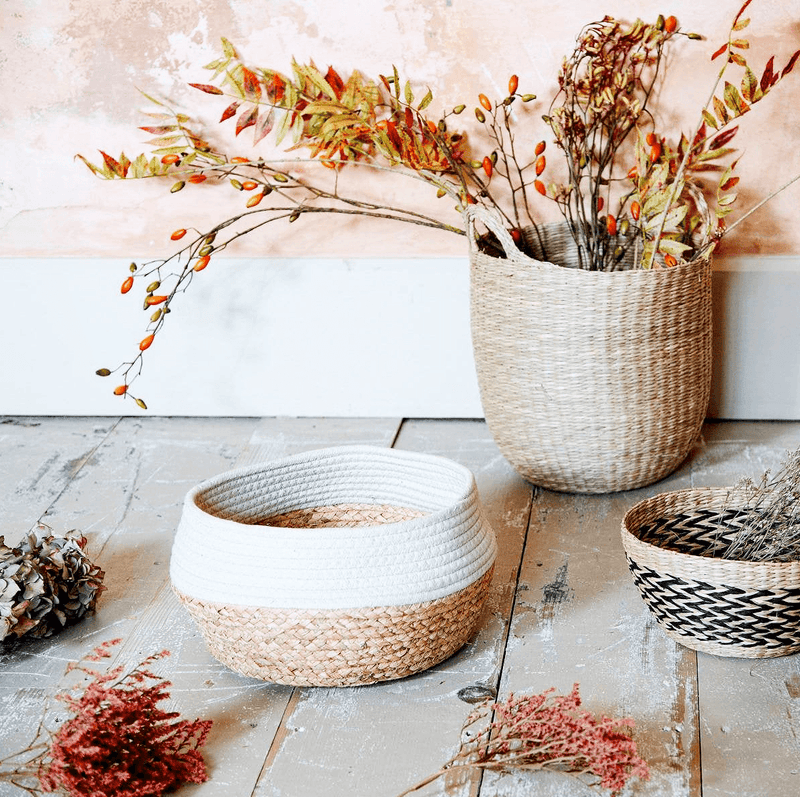 White dip seagrass storage basket styled beside woven baskets and dried flowers