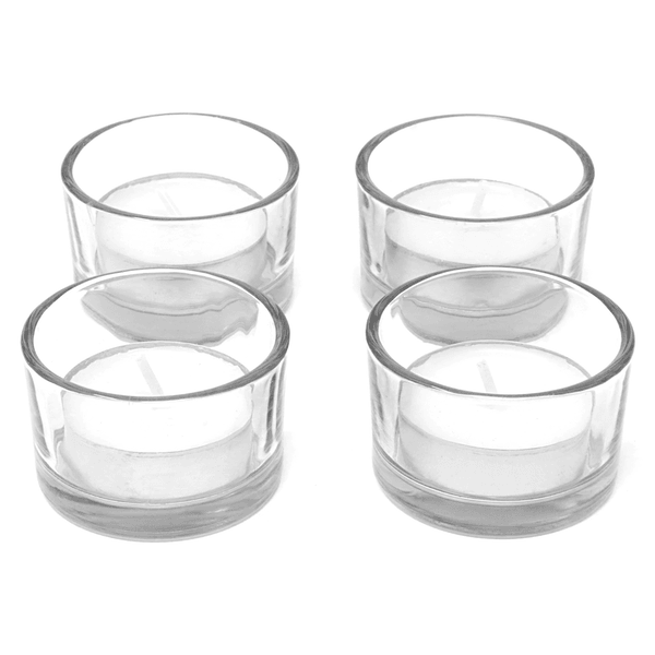 Four empty clear glass tealight holders shown together