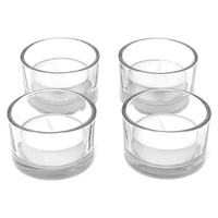 Four empty clear glass tealight holders shown together