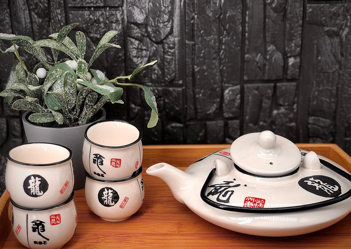White gloss teapot and four cups decorated with black characters and red seals