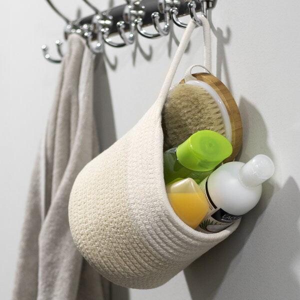 Hanging cotton-blend basket holding toiletries and a brush