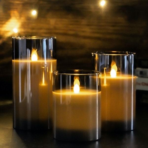 Three grey LED candles illuminated in a dim table setting