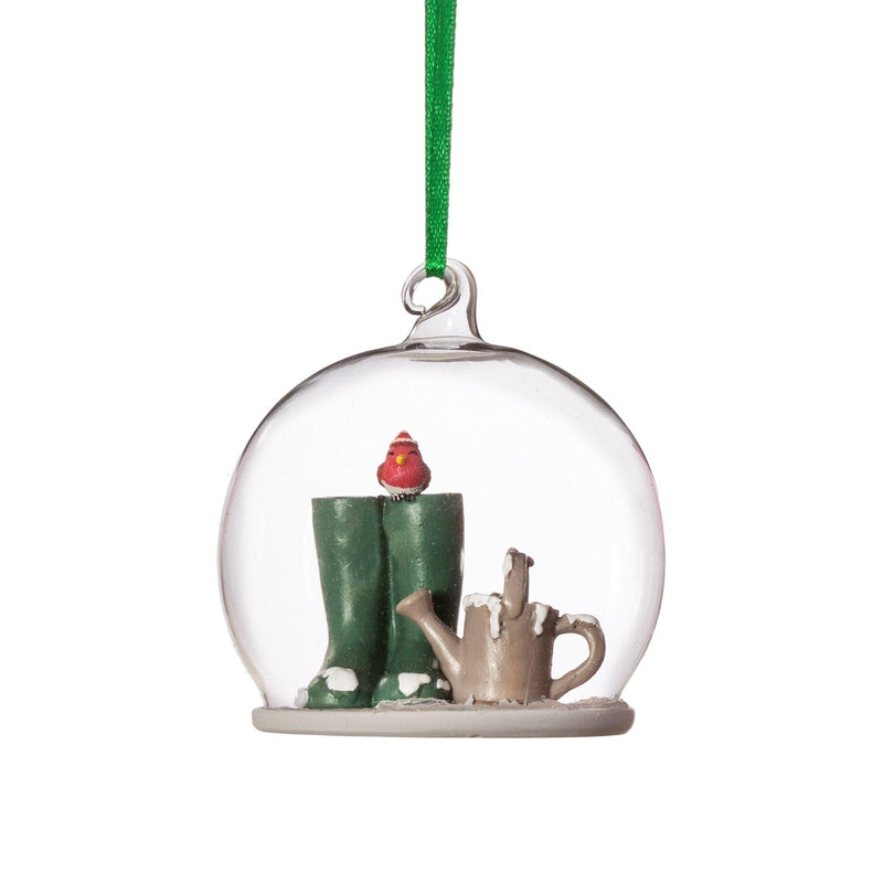 Glass dome Christmas bauble with green wellies, a red robin and watering can, hanging from a green ribbon