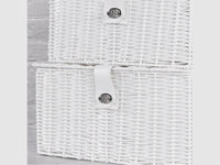 Detail of recessed handles and front fastenings on white woven baskets