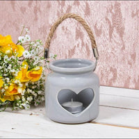 Grey ceramic heart tealight holder with rope handle styled beside flowers