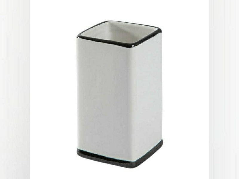 Square white ceramic toothbrush holder with black edging around the rim and base
