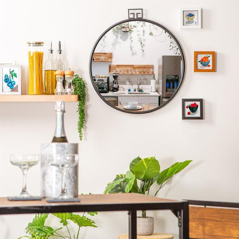 Round black industrial wall mirror styled above a kitchen counter
