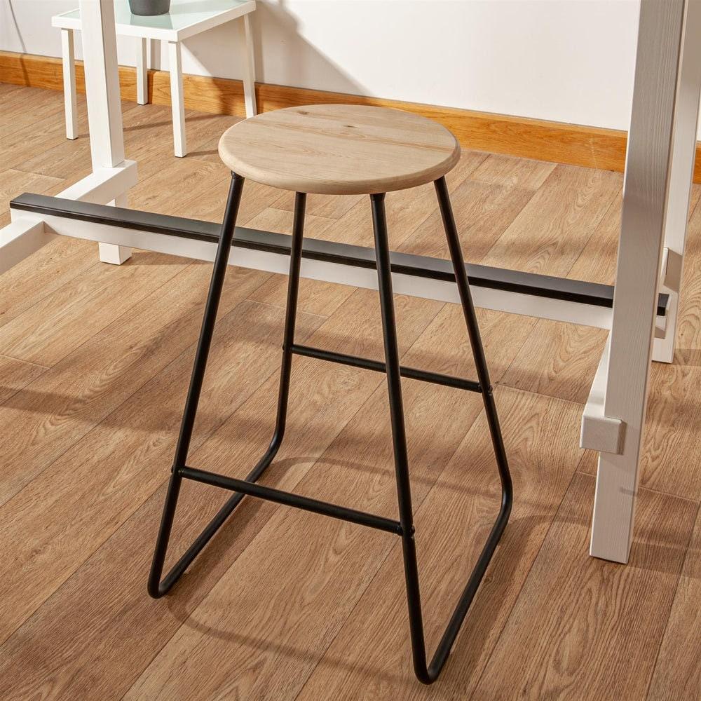 Pine seat bar stool with black metal frame beside a kitchen table